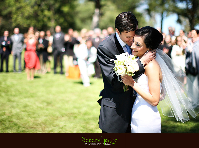 outdoor ceremony, groom hugs bride