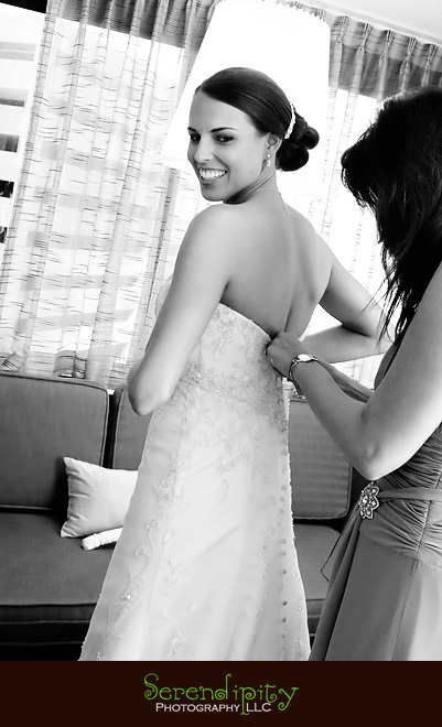 Houston wedding photographer, Hotel Derek, All Saints, maid of honor helping bride with dress