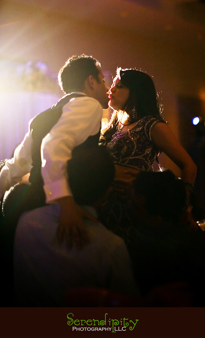 Houston wedding photographer, Hindu Temple, Hindu Wedding, Indian Wedding, bride and groom kissing while being hoisted